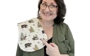 Tara Reed pointing to a baby burp cloth on her shoulder