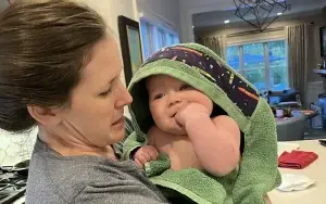 woman holding baby in a hooded towel