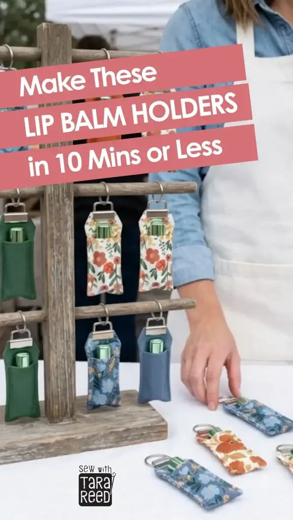 Handmade fabric lip balm holders displayed on a wooden rack at a craft market with text saying they can be made in 10 minutes or less.