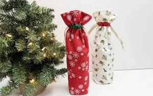 two Christmas themed wine bags with a christmas tree