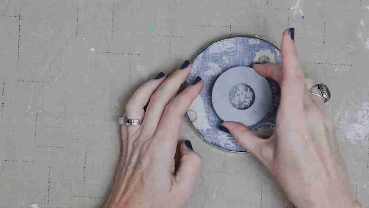 Ring magnet centered on the fabric-covered underside of a glass plate