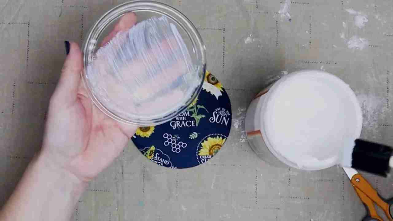 Foam brush spreading white Mod Podge over the bottom of a glass plate